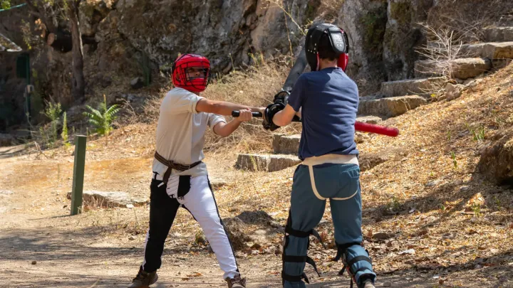 שני משתתפים מתאמנים בסיוף היסטורי במתחם פתוח.