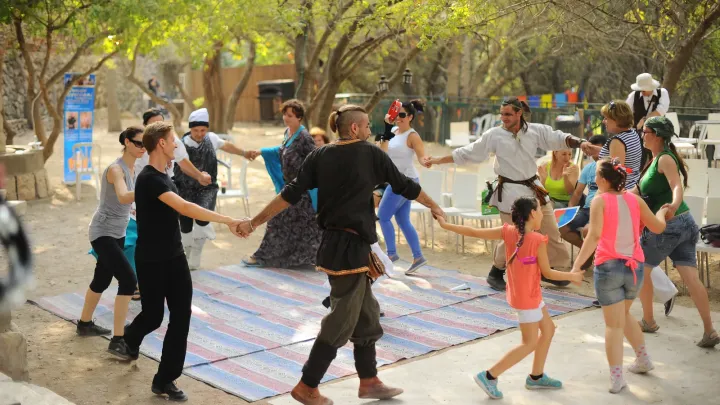 ילדים ומבוגרים משתתפים יחד במעגל ריקוד.