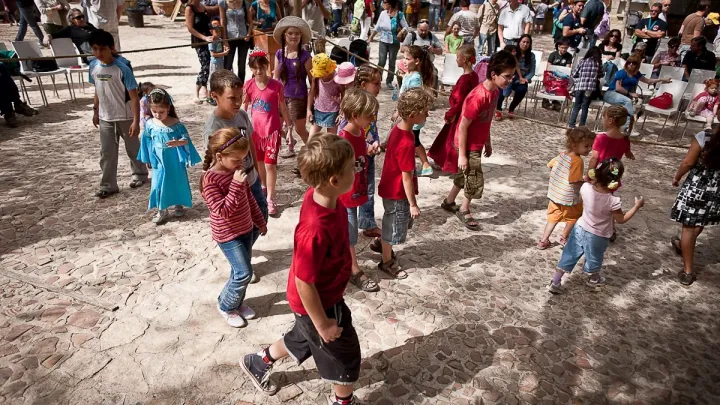 קבוצת ילדים ומבוגרים משתתפת בריקוד משותף בפסטיבל.
